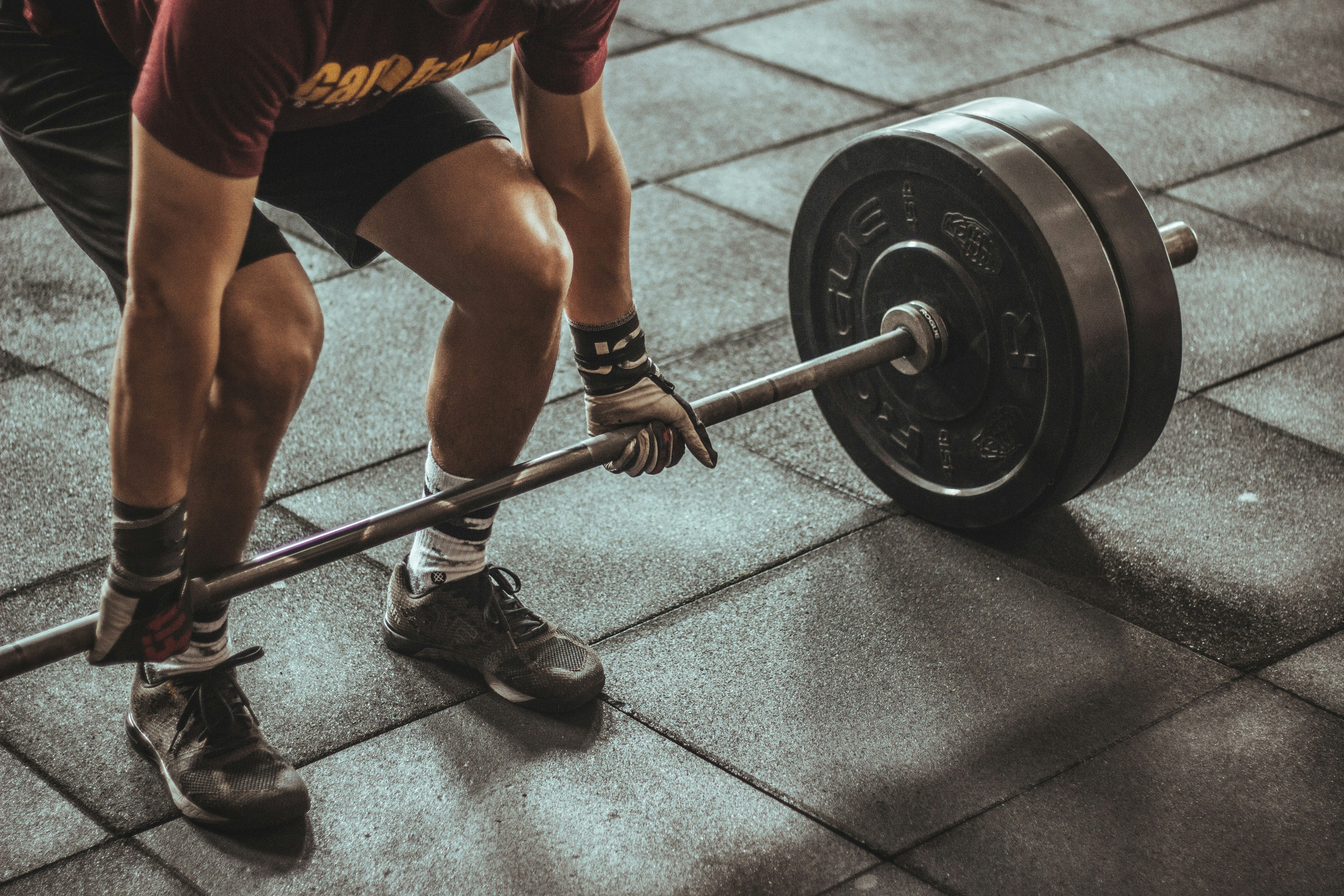 Barbell deadlift on tiled floor.
